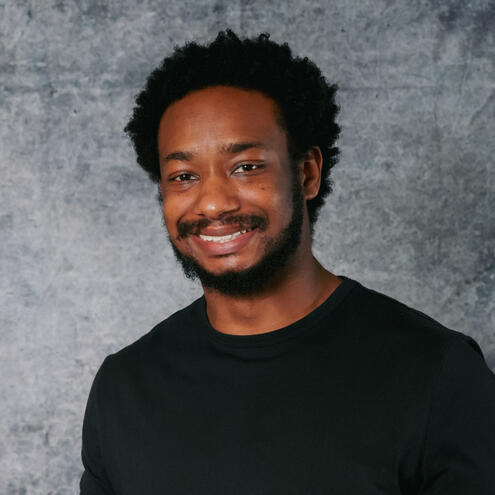 Darrien Staton A picture of Darrien wearing a black t-shirt and smiling.